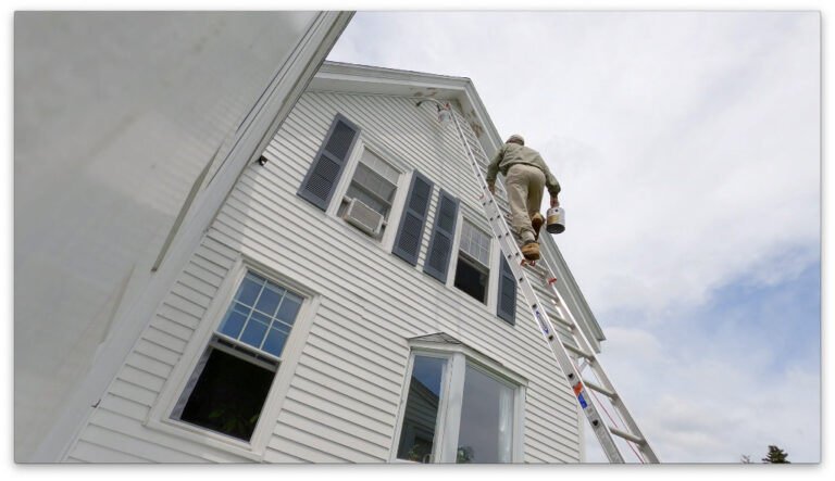 Man Climbs Ladder to Paint House